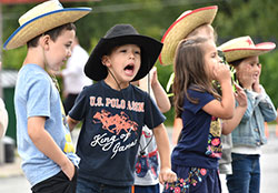 Luis Vuko (center), a pre-kindergarten student at Nativity of Our Savior sings along to country music as he dons a cowboy hat during the Portage school's Hurricane Harvey Hoedown on Sept. 7. Led by the seventh-grade class, students raised $2,400 to send to disaster relief agencies. (Anthony D. Alonzo photo)